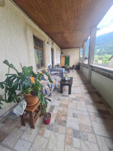 a balcony with couches and plants in a building at Guest House Goshtela in Mestia