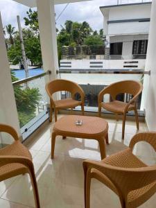 a balcony with chairs and a table and a window at Second home International airport T-1 in Trivandrum