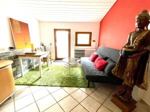 a living room with a statue in the middle of a room at Herzensort - idyllisches Gästehaus für 2 im Garten in Rödermark