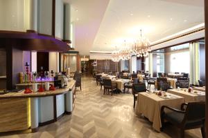 a restaurant with tables and chairs and a chandelier at Chengdu Tibetan Hotel in Chengdu