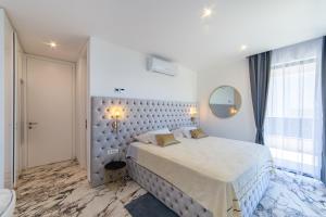 a white bedroom with a large bed and a mirror at Villa Hedonist in Komarna +63 photos