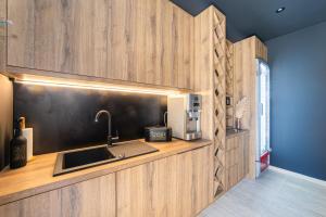 a kitchen with wooden walls and a sink and a counter at Villa Hedonist in Komarna