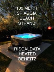uma banheira de hidromassagem no meio de um quintal em Villa Lori Apartments Garden and Beach em Peschiera del Garda