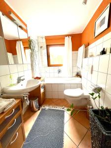 a bathroom with a tub and a toilet and a sink at Wohlfühloase für 10 Personen in Rödermark