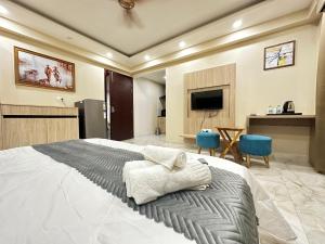 ein Schlafzimmer mit einem großen Bett und einem TV in der Unterkunft Paras Studios By The Lodgers-Serviced Apartments Near Artemis Hospital Gurgaon in Gurgaon