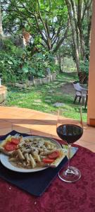 a plate of food and a glass of wine on a table at Villa Chelsey in Valle de Ángeles