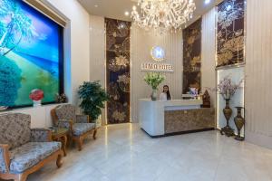 a lobby of a hotel with a reception desk and chairs at HALO HANOI HOTEL in Hanoi