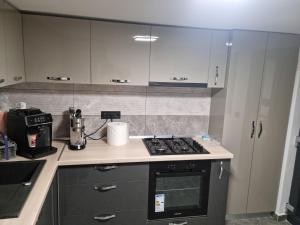 a kitchen with white cabinets and a stove top oven at Vila Ioana & Mirel in Eforie Sud