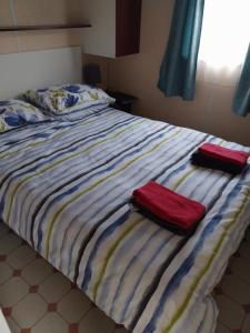 un letto con due asciugamani sopra di Marennes mobilhome 46 Domaine des pins a Marennes