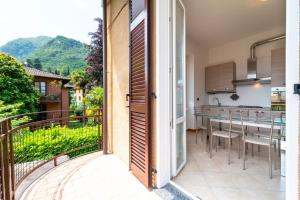 uma porta aberta para uma varanda com uma mesa e cadeiras em Bright and Cozy in Menaggio by Wonderful Italy em Menaggio