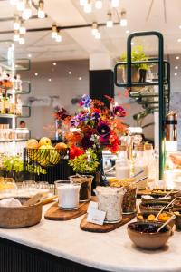 d'un comptoir avec des fleurs et d'autres articles. dans l'établissement Sapphire House Antwerp, Autograph Collection, à Anvers