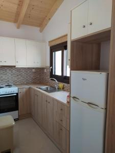 a kitchen with a white refrigerator and a sink at Vigla Village in Spartià