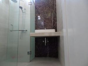 ein Bad mit einem Waschbecken und einer Glasdusche in der Unterkunft ABIMANYU GUESTHOUSE Near Malioboro in Timuran