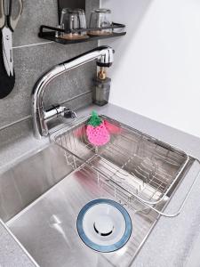 a kitchen sink with a dish rack in it at Harington Gwangan in Busan +52 photos