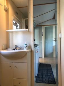 a small kitchen with a sink and a mirror at ATLANDES - Entre lac et mer in Biscarrosse