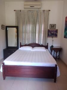 um quarto com uma cama grande e uma janela em Roche's Cozy Corner R-1 Upper Level em Madiwala