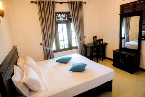 a bedroom with a bed with two pillows on it at Villana Villa Bentota in Bentota