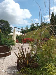 un jardín con una sombrilla blanca y una cruz en B&B Monticelli, en Gubbio