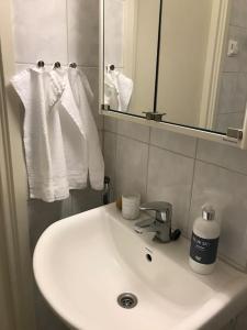 een badkamer met een wastafel, een spiegel en handdoeken bij Fräsch centrumlägenhet! in Mariehamn