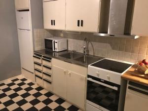 a kitchen with a sink and a microwave at Fräsch centrumlägenhet! in Mariehamn