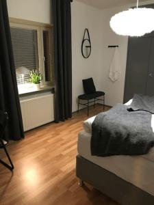 a bedroom with a bed and a wooden floor at Fräsch centrumlägenhet! in Mariehamn