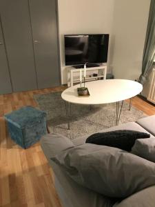 un soggiorno con divano, tavolo e TV di Fräsch centrumlägenhet! a Mariehamn