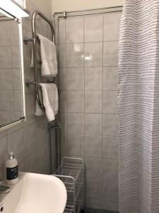 a bathroom with a white sink and a shower at Fräsch centrumlägenhet! in Mariehamn