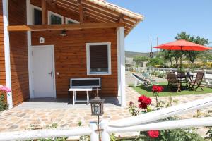 Cette maison dispose d'une terrasse avec une table et un parasol. dans l'établissement Los Laureles Casa Rural, à Urda