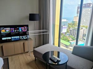 a living room with a couch and a large window at EDGE Central pattaya near walking street in Pattaya Central
