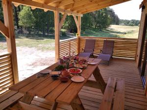 una mesa de madera en un porche con comida. en Wczasy na Kaszubach, en Górki