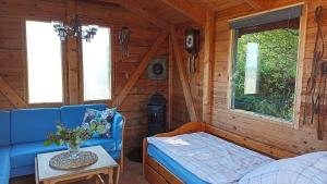 ein Zimmer mit einem Sofa und einem Tisch in einer Hütte in der Unterkunft Ferien am Biotop in Rodenäs