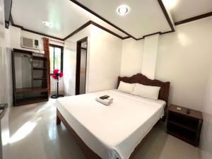 a bedroom with a bed with a phone on it at Alocasia Hostel in El Nido