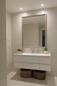 ein Bad mit einem Waschbecken und einem Spiegel in der Unterkunft Apartment Vista By 2bhome in Radovići