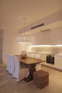 una cucina con tavolo in legno e armadietti bianchi di Apartment Vista By 2bhome a Radovići