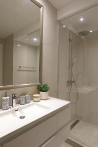 uma casa de banho branca com um lavatório e um chuveiro em Apartment Vista By 2bhome em Radovići
