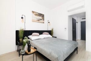 een witte slaapkamer met een bed en een tafel bij EASY RENT Apartments - Smart 5 in Lublin