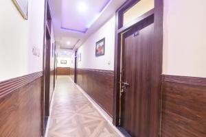 a corridor with wooden doors in a building at FabHotel Sumangal in Gwalior