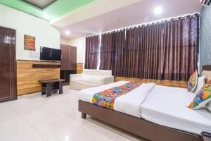 a hotel room with a bed and a television at FabHotel Sumangal in Gwalior