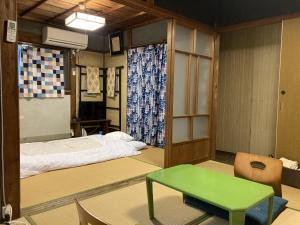 熊野市にあるわがらん家のベッドと緑のテーブルが備わる部屋