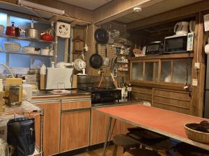 una cocina con armarios de madera y una mesa. en wagaranchi en Kumano