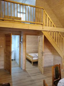 GórkiにあるWczasy na Kaszubachの木製の階段の下に二段ベッドが備わる客室です。