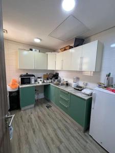 eine Küche mit grünen Schränken und weißen Geräten in der Unterkunft A journey of luxury Seaview living. in Kuwait