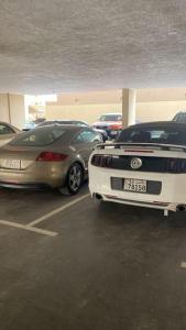 dois carros estão estacionados num parque de estacionamento em A journey of luxury Seaview living. em Kuwait