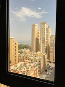 einen Blick aus dem Fenster einer Stadt mit hohen Gebäuden in der Unterkunft A journey of luxury Seaview living. in Kuwait