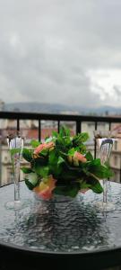 a table with two wine glasses and a bouquet of flowers at City Centre Apartament in Sarajevo