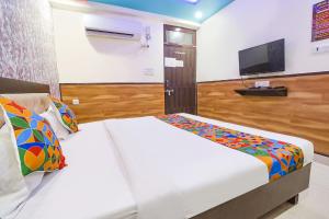 a bedroom with two beds and a flat screen tv at FabHotel Sumangal in Gwalior