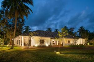 a house with a yard at night at Ceylo Villas in Bentota