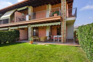 ein Haus mit einem Balkon und einem Hof in der Unterkunft Casa BELLA - POOL Garden Parking in Polpenazze del Garda