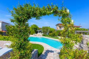 a garden with a swimming pool and a tree frame at Resort Ravenna in Massa Lubrense