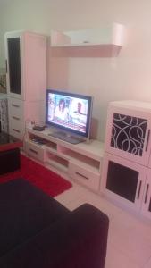 sala de estar con TV en un centro de entretenimiento en Catoira apto vacacional, en Catoira